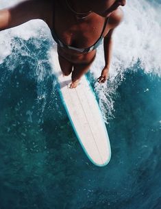 a woman riding a surfboard on top of a wave