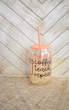 a cup with a straw in it that says coffee teach repeat