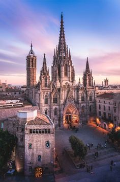 an aerial view of the cathedral in barcelona, spain at sunset with people walking around