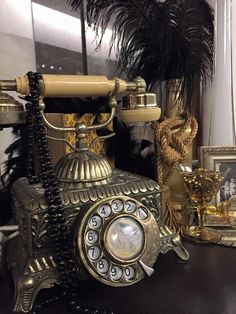 an old fashioned phone sitting on top of a wooden table next to other antique items