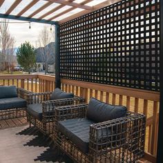 some chairs and couches on a wooden deck with pergolated screens over it