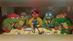 the teenaged turtles are sitting at a table with a camera in front of them