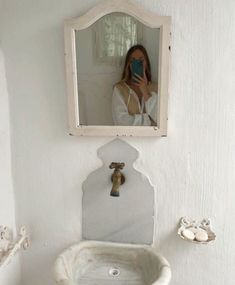 a woman is taking a selfie in the bathroom mirror while she takes a photo