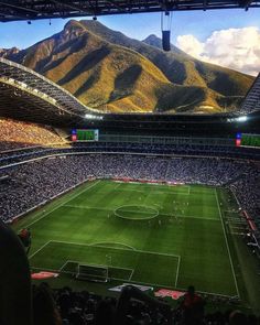 a soccer stadium with mountains in the background