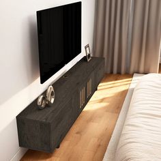 a flat screen tv mounted to the side of a wooden entertainment center in a bedroom