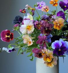 a vase filled with lots of different colored flowers