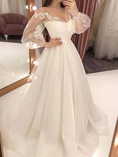 a woman taking a selfie in front of a mirror wearing a white wedding dress