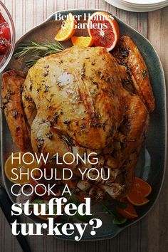 a turkey on a plate with oranges and cranberries next to the words, how long should you cook a stuffed turkey?