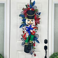 a door hanger with a nutcracker on it's side, decorated in red, white and blue