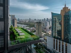 an aerial view of the city with skyscrapers and green roof garden in foreground