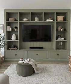 a living room filled with furniture and a flat screen tv on top of a wooden entertainment center