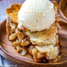 a wooden plate topped with a slice of pie and ice cream on top of it