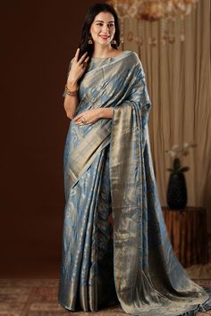 To complement your graceful demeanor, Andaaz Fashion presents this teal blue silk saree which comprises a delightful traditional look.This round neck and puff sleeve blouse is beautified with woven zari work.It is paired with a silk lightweight saree in teal blue color prettified with woven zari work.This blouse can be customized up to the maximum size available in inches 44 around the bust. Slight color variation may occur due to photographic reasons. Traditional Blue Tissue Silk Pre-draped Saree, Teal Silk Saree, Blue Dola Silk Pre-draped Saree With Zari Weaving, Blue Slub Silk Pre-draped Saree With Zari Weaving, Velvet Suit Design, Anarkali Suits Bollywood, Festival Blue Tussar Silk Pre-draped Saree, Blue Silk Saree, Frock Style