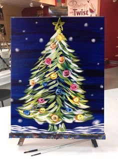 a painting of a christmas tree on a easel