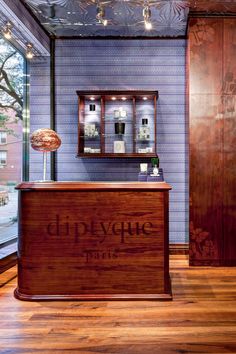 the front desk of an upscale boutique with wooden floors and purple walls, along with glass windows