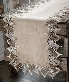 an old wooden bench with a table cloth on it