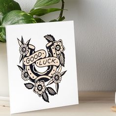 a card with the words good luck on it and some flowers in front of it