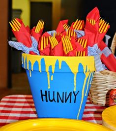 a blue bucket filled with yellow and red napkins sitting on top of a table