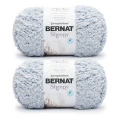 two balls of bernat sheepy yarn in light blue and white, on a white background