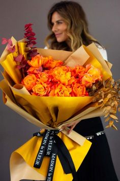 a woman holding a bouquet of orange flowers