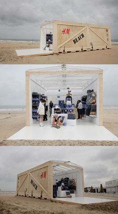 people are standing in the back of a shipping container on the beach, while others look at it