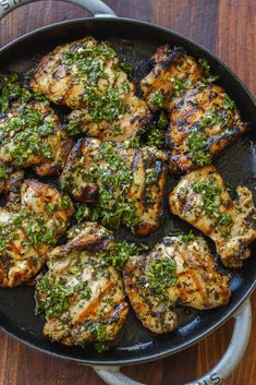 chicken with herbs in a skillet on a wooden table