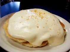 an english muffin covered in white icing on a plate