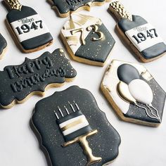 decorated cookies with black and white frosting are arranged in the shape of birthday cakes