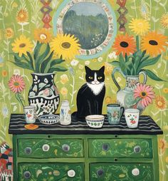 a black and white cat sitting on top of a green dresser next to vases