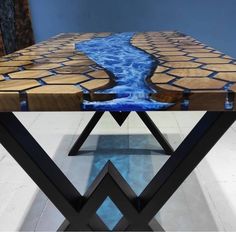 a wooden table with blue water flowing down the center and two black metal legs on each side