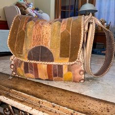 an old purse sitting on top of a wooden table next to a window sill