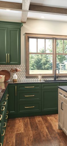 a kitchen with green cabinets and wooden floors