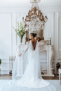 the back of a bride's dress in front of a chandelier