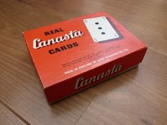 an unopened red card game box sitting on top of a wooden table with the word, real canada cards