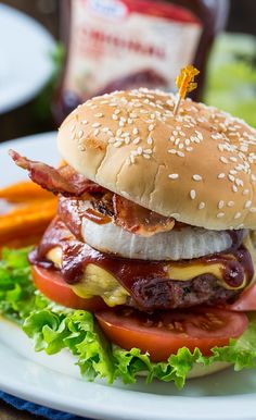 a hamburger with bacon, lettuce and tomato on it