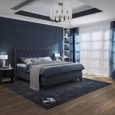 a bedroom with blue walls and wood flooring has a chandelier hanging from the ceiling