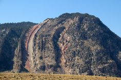 a large mountain with a train on it's side in the middle of nowhere