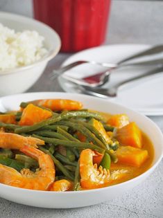 a white bowl filled with green beans and shrimp