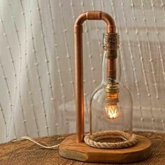 an old fashioned light bulb is turned into a lamp with a wooden base and copper fittings