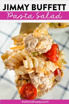 a spoon filled with pasta salad on top of a table