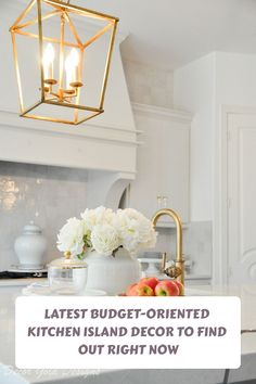 the kitchen island is decorated with white flowers and gold accents, along with a chandelier