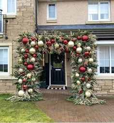 a house decorated for christmas with decorations on the front door and wreaths around it