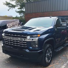 a blue chevrolet truck parked in front of a brick building with the words southern united painted on it