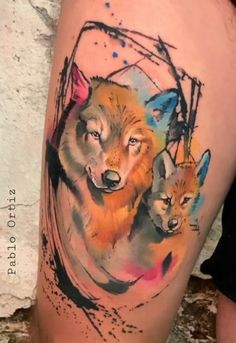 an artistic tattoo with two foxes on the side of a woman's thigh, painted in watercolor and ink