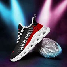 a pair of black and red sneakers on top of a blue and purple stage background