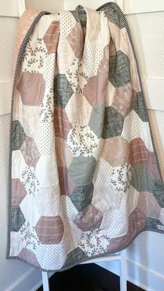 a quilt hanging on the wall next to a chair