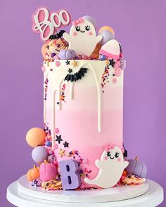 a pink and white birthday cake with sprinkles on the top is decorated with decorations