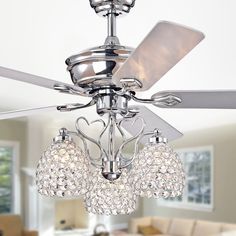 a ceiling fan with three crystal balls hanging from it's blades in a living room