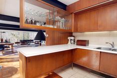 an empty kitchen with wooden cabinets and white counter tops is seen in this image from the inside