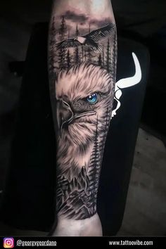 an eagle with blue eyes and trees on it's arm is shown in this tattoo design